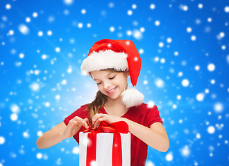 Image showing smiling girl in santa helper hat with gift box