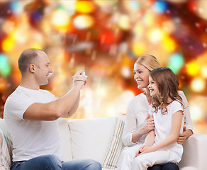 Image showing happy family with camera at home