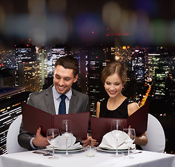 Image showing smiling couple with menus at restaurant