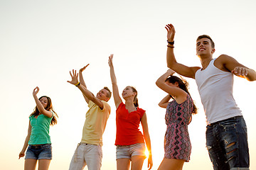 Image showing smiling friends dancing on summer beach