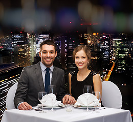 Image showing smiling couple holding hands at restaurant