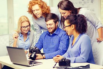 Image showing smiling team with laptop and photocamera in office