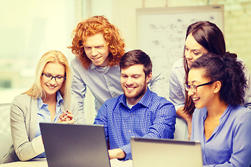 Image showing smiling team with laptop computers in office