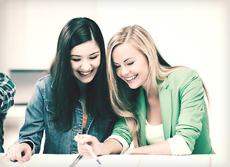 Image showing student girls pointing at notebook at school