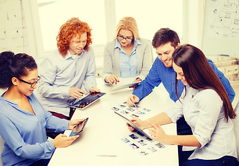 Image showing smiling team with table pc and papers working