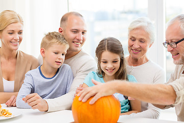 Image showing happy family sitting with pumpkins at home