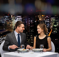 Image showing smiling couple eating main course at restaurant