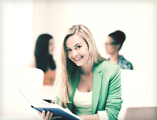 Image showing smiling student girl reading book at school