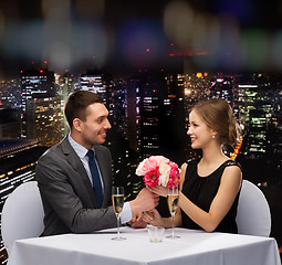 Image showing smiling man giving flower bouquet to woman