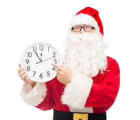 Image showing man in costume of santa claus with clock