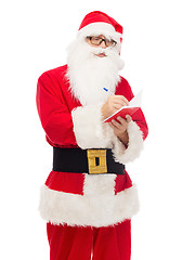 Image showing man in costume of santa claus with notepad