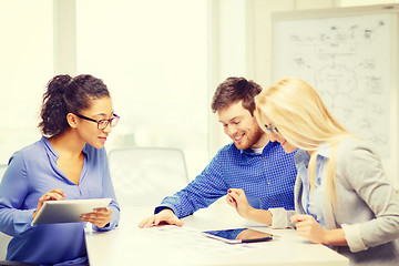 Image showing smiling team with table pc and papers working