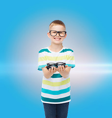 Image showing smiling boy in eyeglasses holding spectacles