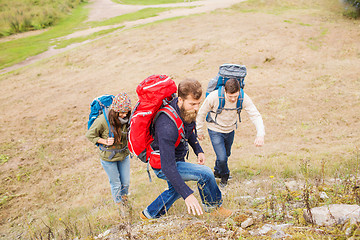 Image showing group of smiling friends with backpacks hiking