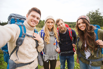 Image showing group of smiling friends with backpacks hiking