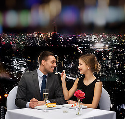 Image showing smiling couple eating dessert at restaurant