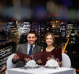 Image showing smiling couple with menus at restaurant