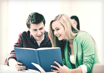 Image showing girl and guy reading book at school