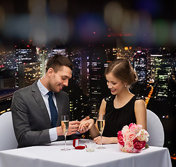 Image showing man proposing to his girlfriend at restaurant