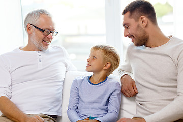 Image showing smiling family sitting on couch home