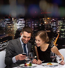 Image showing smiling couple eating main course at restaurant