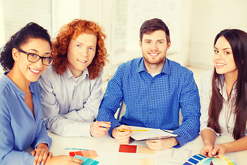 Image showing team with color samples and blueprint at office