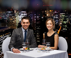 Image showing smiling couple eating main course at restaurant