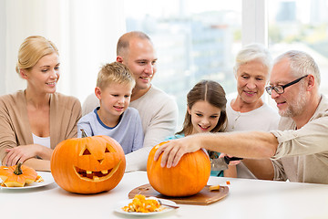 Image showing happy family sitting with pumpkins at home