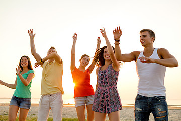 Image showing smiling friends dancing on summer beach