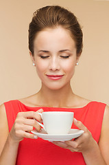 Image showing smiling woman in red dress with cup of coffee