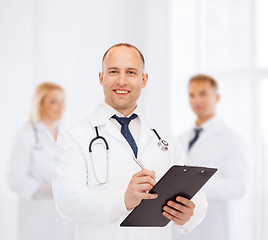 Image showing smiling male doctor with clipboard and stethoscope