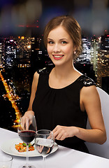 Image showing smiling young woman eating main course