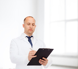 Image showing serious male doctor with clipboard