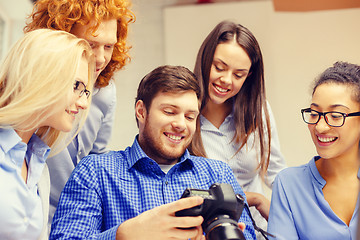 Image showing smiling team with photocamera in office