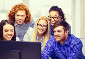 Image showing smiling business team looking at computer monitor