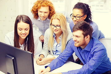 Image showing smiling business team looking at computer monitor