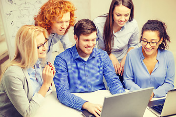 Image showing smiling team with laptop computers in office