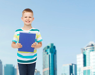 Image showing smiling little student boy with blue book