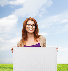 Image showing smiling teenage girl in glasses with white board