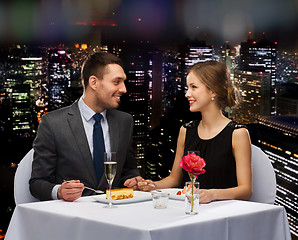 Image showing smiling couple eating dessert at restaurant