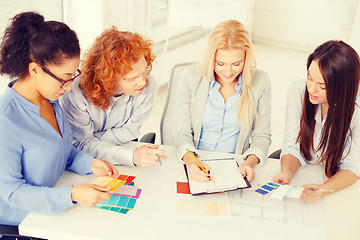 Image showing team with color samples and blueprint at office