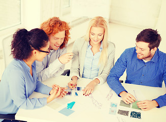 Image showing smiling creative team looking at sketch