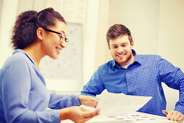 Image showing smiling team with paper at office