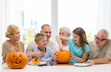 Image showing happy family sitting with pumpkins at home