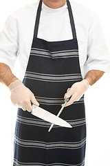 Image showing Butcher sharpening a knife