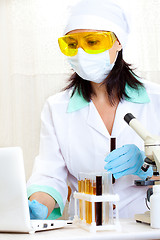 Image showing doctor looking at a test tube of black solution