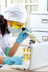 Image showing scientist looking into microscope