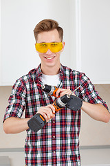 Image showing Worker with electric drill and scredriver