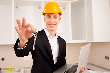 Image showing smiling engineer gives keys