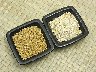 Image showing Bowls of chinaware with cereal and wholemeal on rattan underlay